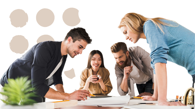 Vier Teammitglieder arbeiten gemeinsam konzentriert an einem Tisch.